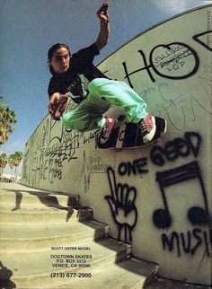 a man riding a skateboard down the side of a cement wall covered in graffiti