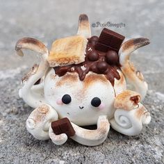 a small ceramic figurine with chocolate on it's head sitting on the ground