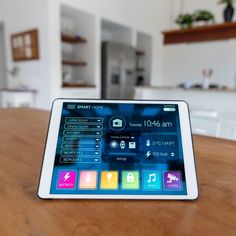 an ipad sitting on top of a wooden table in front of a white kitchen island