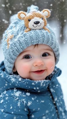 a baby wearing a blue coat and hat in the snow