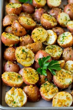 baked potatoes with herbs and seasoning in a baking pan, ready to be eaten