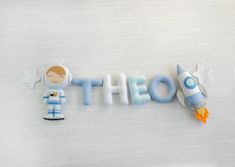 the word thoe spelled out in felt with a toy rocket next to it