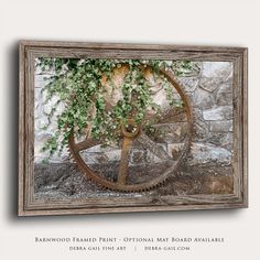 an old wooden wheel with ivy growing on it in front of a stone wall and frame