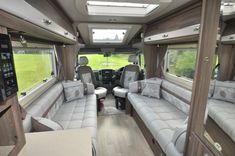 the interior of an rv with couches and windows