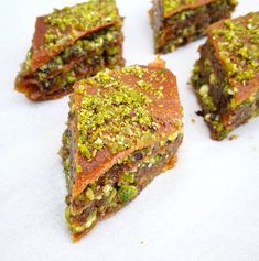 four pieces of food that are sitting on a white tablecloth covered in green and yellow sprinkles