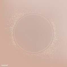 a circle with gold dots in the middle on a light pink background that is slightly blurry