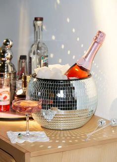 a disco ball is sitting on a table next to a wine glass and bottle in it