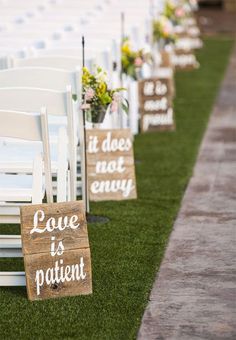 chairs lined up on the grass with signs attached to them that read love is patient, love is kind