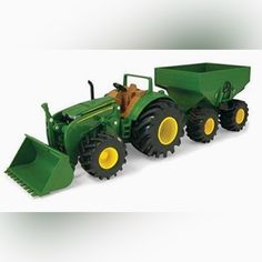 a green toy tractor with two large wheels and yellow tires on it's sides