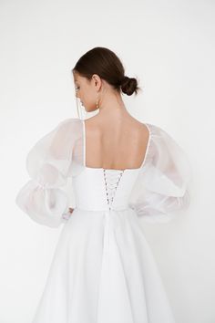 the back of a woman wearing a white dress