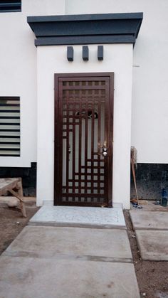 a white building with a wooden door and bench