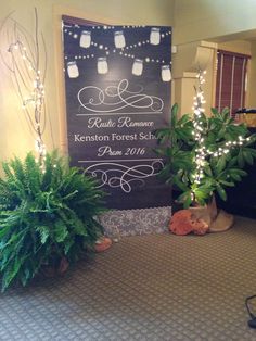 two potted plants sitting on top of a carpeted floor next to a sign