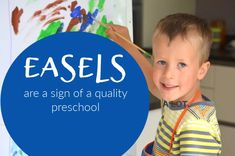 a young boy holding a paintbrush and painting an easel with the words easels are a sign of a quality preschool