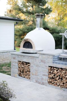 an outdoor pizza oven with logs stacked on it and the words hey landyn above it