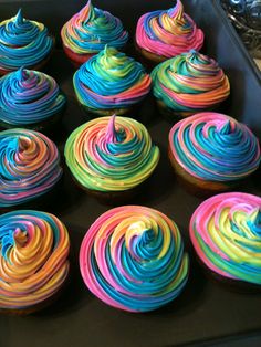 there are many cupcakes with different colored frosting