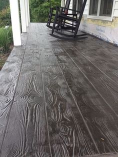 a wooden porch with rocking chairs on it