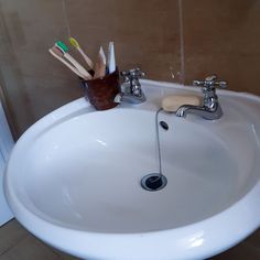 a bathroom sink with toothbrushes and soap in it