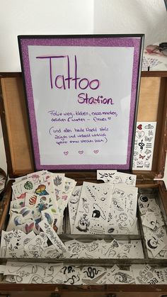 an open suitcase filled with lots of tattoos on it's sides and the words tattoo station written in purple ink