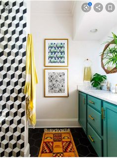 a bathroom with black and white tiles on the floor, green cabinets and yellow towels