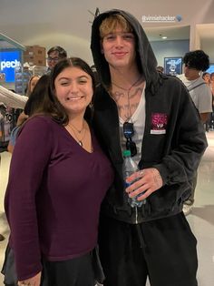 a man in a hoodie standing next to a woman