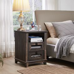 a night stand with two drawers and a lamp