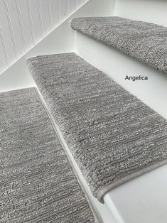 two gray rugs sitting next to each other on top of a white countertop