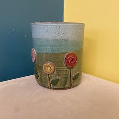 a flower pot sitting on top of a table next to a blue and yellow wall