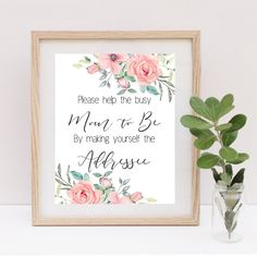 there is a vase with some flowers in it next to a framed sign that says, please help the busy mom to be by making yourself