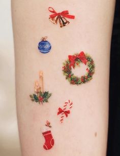 a woman's arm with christmas decorations and ornaments on the side of her body