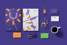 an assortment of stationery items on a purple background with a coffee cup and scissors