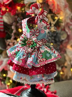 "CHRISTMAS SWEETS TRI-FABRIC RUFFLE DESIGN DRESS FEATURES BRIGHT PEPPERMINT CANDY, RED POLK-A-DOT & BAKING FOR CHRISTMAS PRINTS. EMBELLISHED W/ BRIGHT PINK RICK-RACK & WHITE LACE TRIMS ON THE RUFFLES, ACCENT BOW W/ CANDY CENTER & LEASH D-RING.  MATCHING HAIR BOW AVAILABLE. (PAIR W/ OUR CHRISTMAS PLAID OR GINGERBREAD PLAID VESTS FOR SIBLING/HOLIDAY PICS)   PRICING: XXS & XS -- $95 S & M -- $100 L & XL -- $105 HAIR BOW - $12 SIZING: So that we don't leave any of our little ones out, we have our pet clothing lines available in both female and male items, sizes XXSmall to XLarge (See Size Charts in photos).  If you need help choosing the best size or in need of an altered pattern, please contact us for assistance.  We would love to help! ORDERING: ALL ITEMS ARE MADE CUSTOM TO ORDER, AND ALL SA Sleeveless Ruffled Holiday Dress, Fitted Christmas Holiday Dress With Ruffles, Fitted Christmas Dress With Ruffles, Winter Holiday Dress With Ruffles, Fitted Holiday Dress With Ruffles For Christmas, Pink Ruffled Holiday Dress, Christmas Holiday Dress With Ruffles, Holiday Dress With Ruffles For Christmas, Holiday Dress With Ruffles