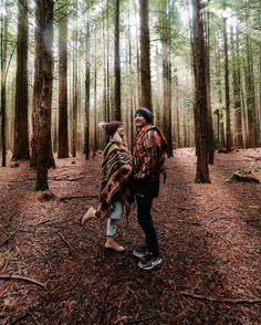 two people are walking through the woods together