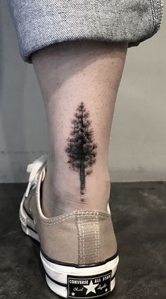 a small pine tree tattoo on the ankle