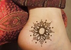 a woman's foot with a henna tattoo on it