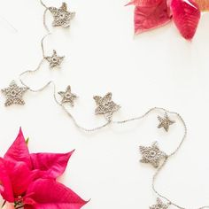 the flowers are laying on the table next to the silver necklaces and flower petals