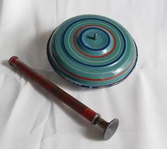 an old baseball bat sitting next to a blue and red container on a white sheet