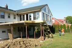 two men are working on a house under construction