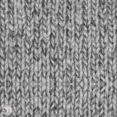 a close up view of the texture of a knitted fabric with grey and white colors