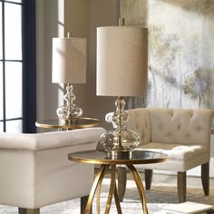 a living room filled with furniture and a lamp on top of a table next to a couch