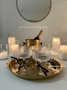 there is a tray with wine glasses and candles on it