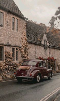 an old car is parked on the side of the road in front of some houses