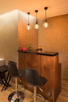 a bar with three stools in front of it