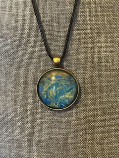 a necklace with a blue and yellow pendant