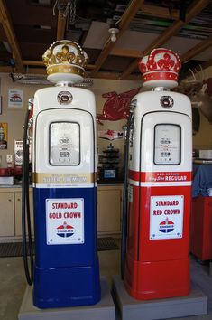 two red, white and blue gas pumps sitting next to each other