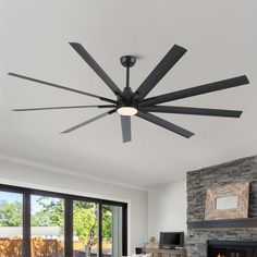 a living room with a fire place and a ceiling fan that is black in color