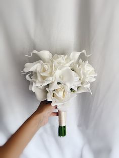 a person holding a bouquet of white flowers