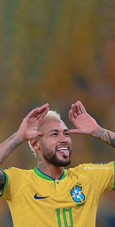 a soccer player with his hands up in the air, smiling and making a funny face