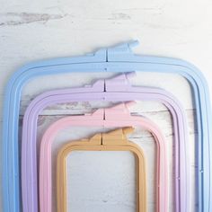 three different colored plastic frames hanging on a wall