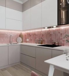 a white kitchen with pink tiles on the backsplash and counter tops is shown