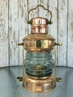 an old fashioned brass and glass lantern on a table